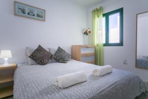 a bedroom with a bed with two towels on it at Lanzholidays in Tías