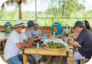 a group of people sitting around a wooden table at SIP Garden Villa in Cibeuteung Udik