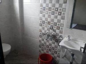 a bathroom with a sink and a toilet at Hotel Shri Sai Ashwariya inn in Shirdi