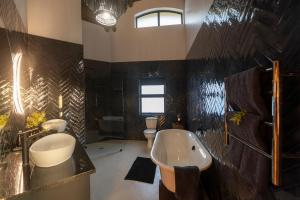 a bathroom with a tub and a sink and a toilet at Gondwana Game Reserve in Kleinberg +53 photos