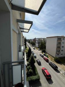 un balcón con vistas a una calle con coches aparcados en Útulný byt blízko centra, en Trenčín 1 foto más