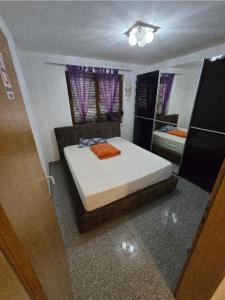 a small bedroom with a bed and a mirror at Stan na Dan Cazin in Ivišovo Greblje