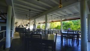 a dining room with tables and chairs in a building at Jungle Nature Villa in Sigiriya