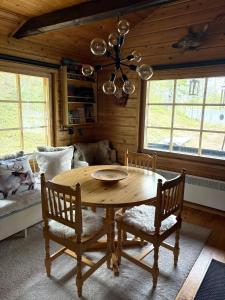 a dining room with a wooden table and chairs at Villa Aiku in Leppäjärvi