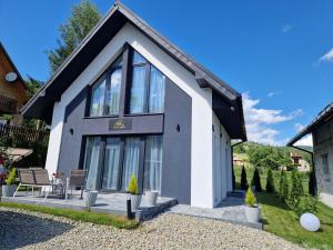 una casa en blanco y negro en Domki na Wypasie - Jaworki, en Jaworki