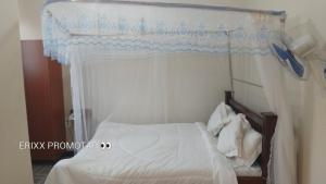 a bedroom with a white bed with a canopy at Sea Ville Resort Hotel And Spa Limited in Mayuge