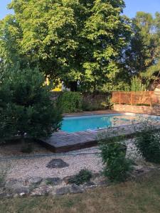 a swimming pool in a yard with a tree at Agape in Vailhourles