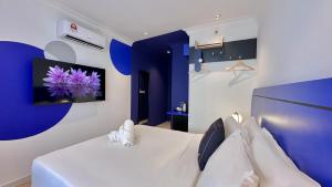 a room with a bed with a tv on the wall at Ukiyo Hotel by manatidur in Petaling Jaya