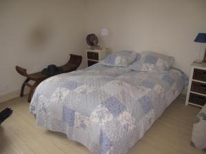 トゥルヴィル・シュル・メールにあるLa Maison Bleue, authentique et charmante maison de pêcheurのベッドルーム1室(青と白のキルトのベッド1台付)