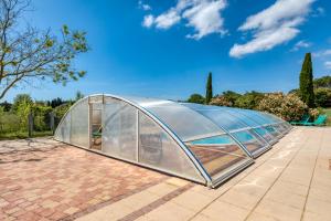 AspiranにあるMaison Abricot avec piscineのレンガ造りのパティオにあるガラス温室