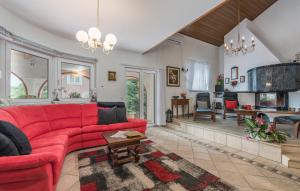 un soggiorno con un divano rosso e una cucina di Villa Anna with pool by Porec a Poreč (Parenzo)