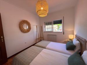 a bedroom with two beds and a mirror at Casa Na Vila in Vila Pouca de Aguiar