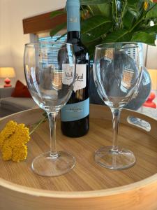 two wine glasses on a table with a bottle of wine at Casa Na Vila in Vila Pouca de Aguiar