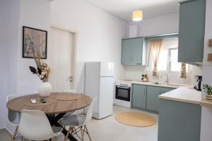 a kitchen with a table and a white refrigerator at Olia's House in Skala Eresou
