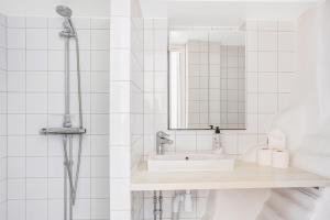 a white bathroom with a sink and a shower at Apartment in Old Town in Stockholm
