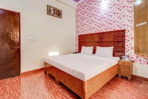 a bedroom with a large bed with a brick wall at Butola guest house in Dehradun
