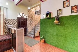 a living room with a green wall and stairs at Butola guest house in Dehradun