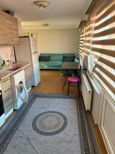 una pequeña cocina con sofá y mesa en gökçedeniz apartment, en Trabzon