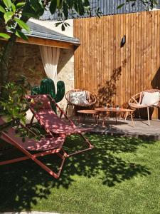 a patio with chairs and a table and a fence at Le Nid défendu #Nüit#love#luxe in Tours