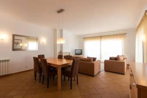 a living room with a table and a couch at T2 piscina e vista mar Praia del Rey Óbidos A6 in Casal da Lagoa Seca