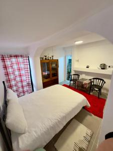 a bedroom with a large white bed and a kitchen at Kıbrıs Evi (Cyprus House) in Famagusta +4 photos