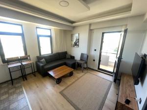 a living room with a couch and a coffee table at Spacious and modern apartment with a view in Gökçeada