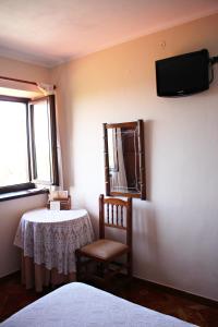 a room with a table and a tv on the wall at Casa de Aldea El Valle in Buelna