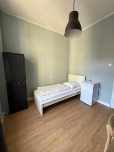 a small bedroom with a bed and a black cabinet at 1, 2, sleep Boardinghouse München Hauptbahnhof in Munich
