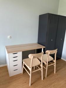 a desk with two chairs and a desk and cabinets at 1, 2, sleep Boardinghouse München Hauptbahnhof in Munich +3 photos