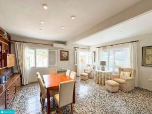 een woonkamer met een eettafel en stoelen bij casa frente el mar in Denia