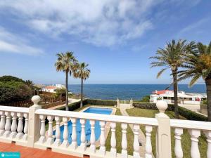 een balkon met een wit hek en een zwembad bij casa frente el mar in Denia