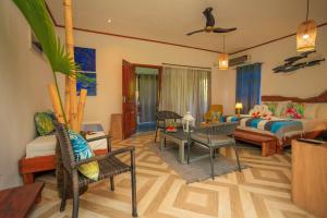 a living room with a bedroom with a bed and a couch at Milles Montagnes Residence in Anse a La Mouche