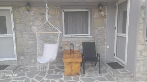 a porch with a hammock and a chair and a building at Rahati in Pramanta - Ραχάτι στου Τσακτσίρα in Pramanta +19 photos