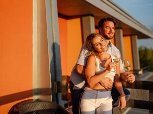 a man and a woman holding a glass of wine at OREA Resort Panorama Moravský kras in Blansko