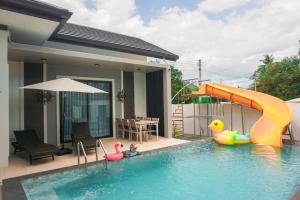 a swimming pool with a slide in a house at Fedora Moon Pool Villa Khanom in Khanom