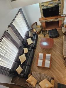 a living room with a leather couch and a television at Naivasha Moi Southlake Villas in Naivasha
