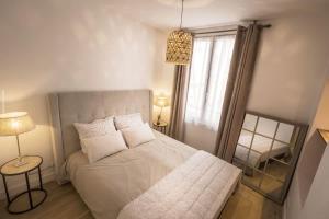 een slaapkamer met een bed, een raam en een spiegel bij Bel appartement à 2 pas du vieux port in La Rochelle
