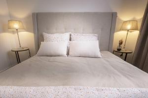 een slaapkamer met een groot wit bed met twee lampen bij Bel appartement à 2 pas du vieux port in La Rochelle