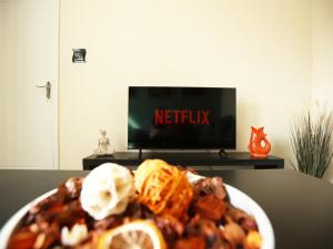 纽波特Malpas House By N And N Stays Ltd, 5 Bedroom house sleeps 8 Perfect for Contractors & Workers, Free Pvt Parking, Fast Wifi, Close to M4 and local amenities的桌子上放着一盘食物,放着电视