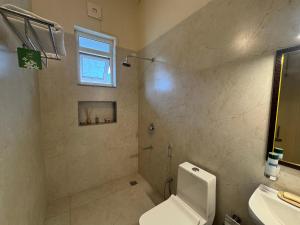 Un baño con inodoro, lavabo y ventana. en The Cliff House, 3BR LUX Villa 2km to Rajpur Road, en Dehradun 22 fotos más