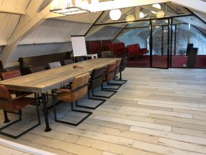 a long table and chairs in a large room at Boutique Hotel Noordeinde in Rijnsburg