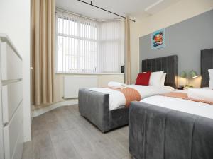 纽波特Malpas House By N And N Stays Ltd, 5 Bedroom house sleeps 8 Perfect for Contractors & Workers, Free Pvt Parking, Fast Wifi, Close to M4 and local amenities的有两张床和一扇窗户的卧室