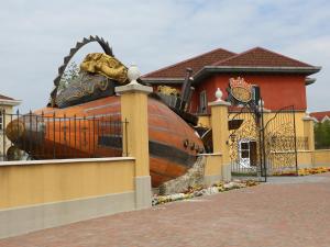 a house with a large wooden boat next to a building at Gardaland Adventure Hotel in Castelnuovo del Garda