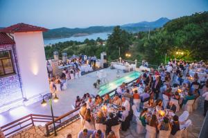 una multitud de personas de pie alrededor de una piscina en una boda en Nevros Hotel Resort and Spa en Neochori