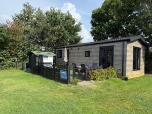 a small house with a fence in a yard at Nieuw in 2025! Modern vakantiehuis aan de Waddenzee in Westerland
