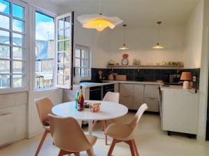 a kitchen with a white table and chairs at Appartement au port de Dinan Belle île in Dinan