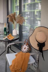 un cappello seduto su una sedia accanto a un tavolo di Mediteraneo Apartment Alezzi Beach Spa&Pool Resort a Mamaia