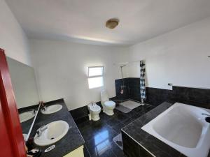 a bathroom with two sinks and a tub and a toilet at Villa BleuBlanca Tangier in Tangier