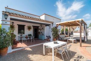 eine Terrasse eines Hauses mit einem weißen Tisch und Stühlen in der Unterkunft Casa Rural Carula in La Puebla de Cazalla