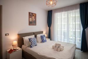 una camera da letto con un letto con due animali di peluche sopra di Mediteraneo Apartment Alezzi Beach Spa&Pool Resort a Mamaia Altre 50 foto